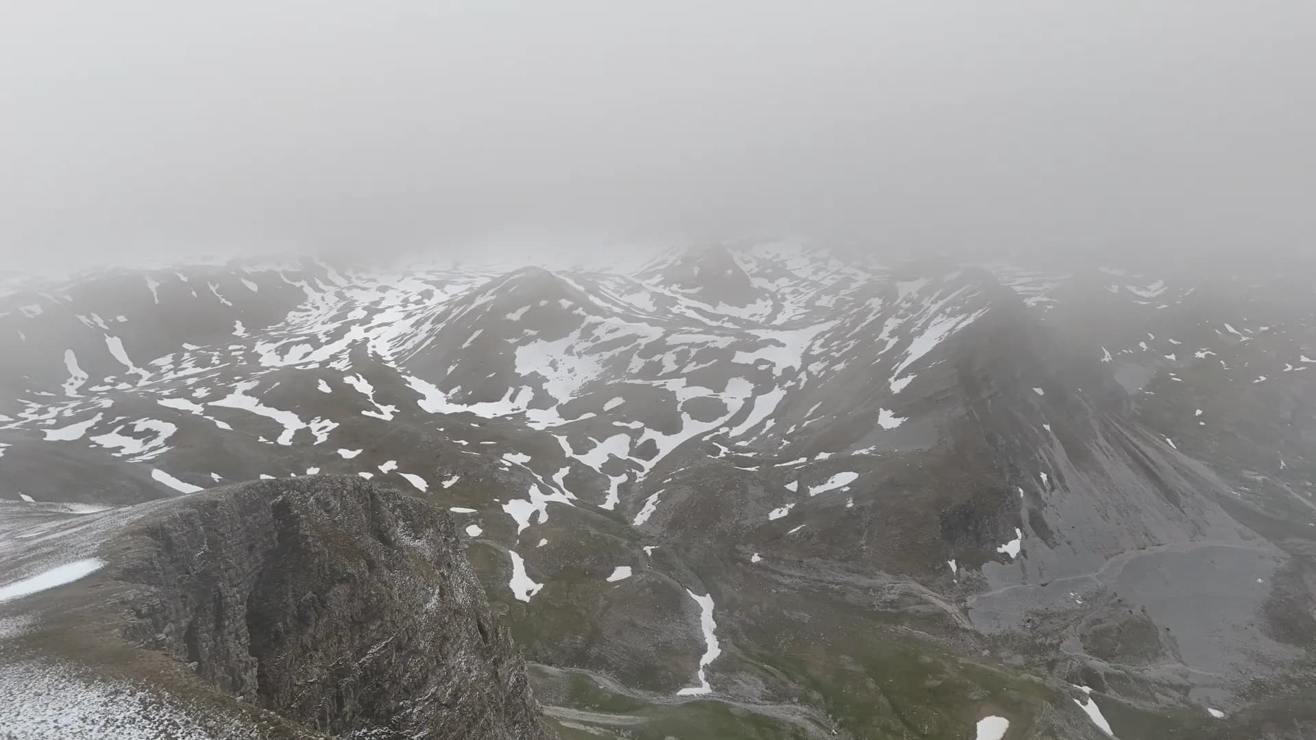 Snježni nameti i magla nad planinskim masivom